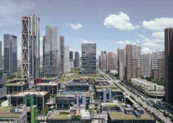 Modern city skyline with tall buildings and blue sky.