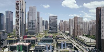 Modern city skyline with tall buildings and blue sky.