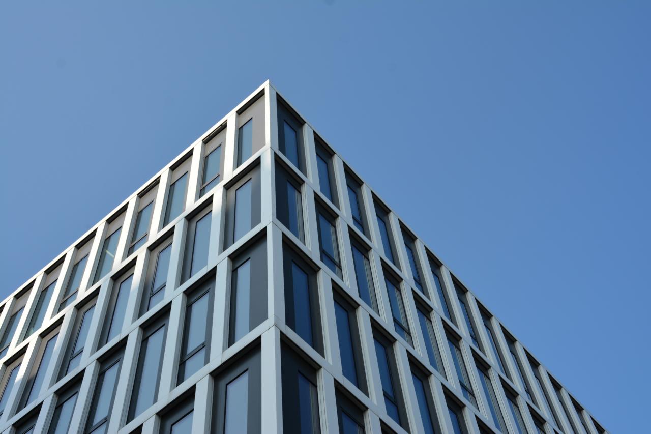 Sebuah gedung tinggi dengan banyak jendela di langit biru